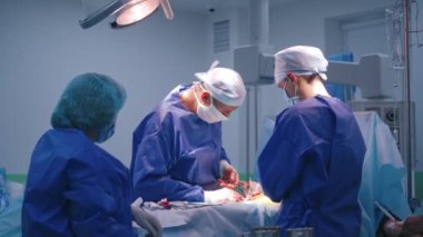 Cerrahlardan oluşan bir ekip bir operasyon gerçekleştirir. Ameliyathanede tıbbi aletlerle ameliyat yapan asistanları olan profesyonel bir doktor..