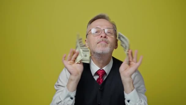 幸せな老人はお金を楽しんでいる 彼の手に多くのドル紙幣を持つ古いビジネスマンの肖像画 素晴らしいビジネス契約 — ストック動画