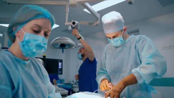 外科部門について 現代のオペレーティングルームで手術を行う医師とアシスタント 医療コンセプト — ストック動画