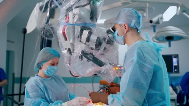 Cirujano Masculino Haciendo Cirugía Microscópica Médico Asistente Usan Microscopio Quirúrgico — Vídeos de Stock