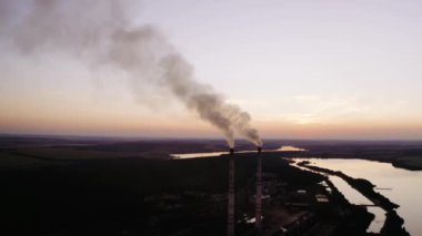 Akşamları doğadaki sanayi fabrikası. Fabrika bacalarından kimyasal duman çıkıyor. Çevre kirliliği kavramı.