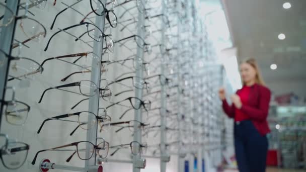 Optik Mağaza Kadın Gözlük Seçiyor Gözlükçüdeki Stantlarda Yeni Gözlükler Var — Stok video