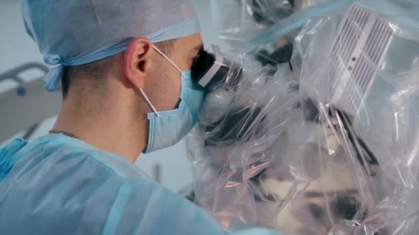 病人在诊所的操作过程 外科医生在显微镜下做手术 女护士帮助医生 — 图库视频影像