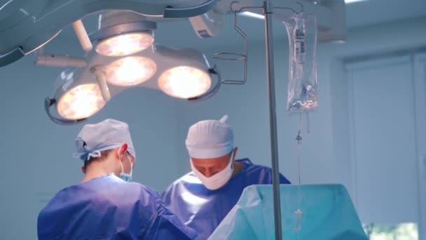 外科手術をする医師 現代の診療所の演劇の上の明るいランプ 医療コンセプト — ストック動画