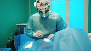 Doktor ameliyattan önce bir hastaya iğne yapıyor. Koruyucu tıp üniformasında uzman bir erkek modern klinikte ameliyat yapıyor..