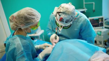 Ameliyathanede ameliyat sırasında iki cerrah. Profesyonel bir doktor ve modern bir hastanede özel ekipmanla estetik ameliyat yapan bir hemşire..