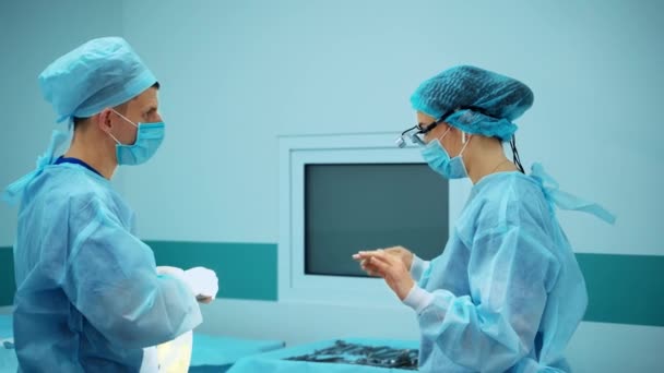 수술실에서 외과의사와 조수는 의사가 플라스틱 장갑을 착용하는 도움이됩니다 — 비디오