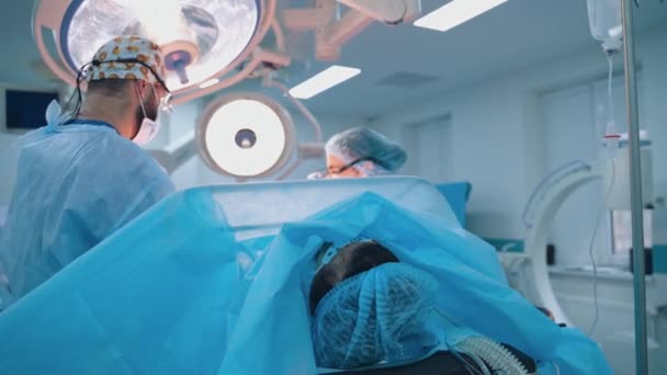 Ασθενής Είναι Ξαπλωμένος Χειρουργικό Τραπέζι Στην Κλινική Επαγγελματίες Γιατροί Κάνουν — Αρχείο Βίντεο
