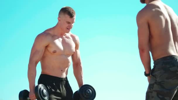 Sportowcy Muskularni Trenują Przeciwko Błękitnemu Niebu Dwóch Sportowców Bez Koszuli — Wideo stockowe