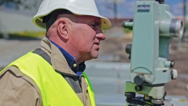 労働者の側面の肖像画 太陽光発電所の建設中に現場に立っている均一で硬い帽子の男性エンジニア クローズアップ — ストック動画