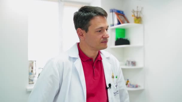 男医生听别人讲话的肖像 一位穿着白衣的英俊男子在私人诊所为一位病人提供咨询 保健概念 — 图库视频影像