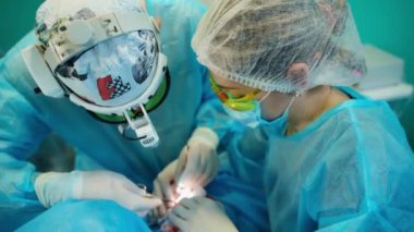 Cerrah ve hemşire ameliyat yapıyor. Steril eldivenli profesyonel doktor ameliyat sırasında tıbbi aletlerle çalışıyor..