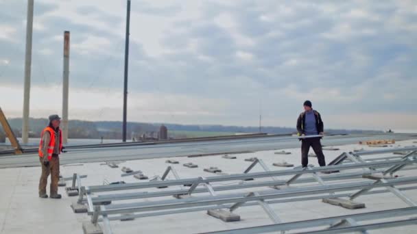Metalowa Konstrukcja Płaskim Dachu Budynku Dwóch Pracowników Instalujących Metalową Bazę — Wideo stockowe