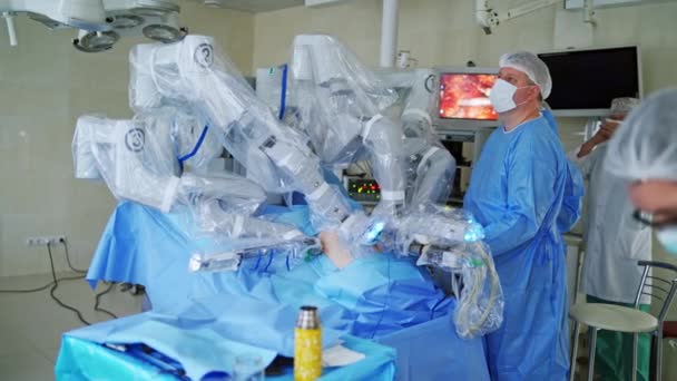 ロボット設備を備えた病院の外科室 外科手術を最小限に抑える未来的な手術室の機械アーム 専門家が医療ロボットの仕事をコントロール — ストック動画