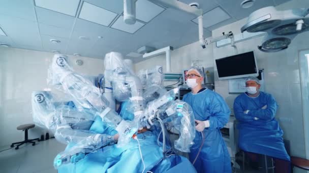 ロボットマシンは患者に操作を行います 現代のオペレーティングルームでの手術プロセス 医療専門家がクリニックで医療ロボットの仕事をコントロール — ストック動画