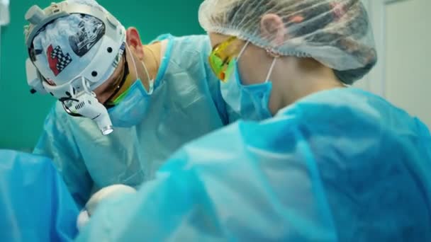 Pracownicy Medyczni Maskach Okularach Podczas Operacji Lekarz Latarce Chirurgicznej Głowie — Wideo stockowe