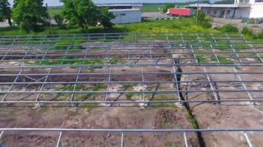 Güneş panelleri için metal yapım alanı. Doğa arasında yeni bir güneş enerjisi santrali inşa etmek. Hareket kamerası geri.