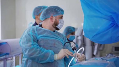 Ameliyathanede üniformalı bir grup doktor var. Klinikte tıbbi malzemeler kullanarak böbreklere ameliyat yapan profesyonel bir cerrah..