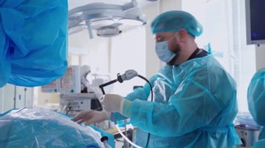 Klinikte ameliyat yapan erkek bir maske uzmanı. Modern ameliyathanede böbrekler üzerinde ameliyat yapan tıp üniformalı profesyonel bir doktor..
