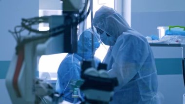 Salgın sırasında klinikte yaşam destek ekipmanları. Korunaklı üniformalı ve maskeli Coronavirus sağlık görevlileri hastanede. Yapay akciğerler havalandırma. Covid 19.