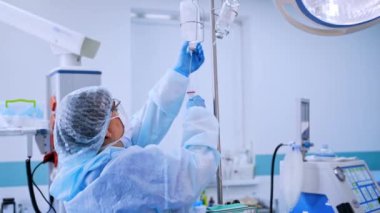 Modern klinikte hemşire üniforması. Koruyucu kıyafetli, maskeli ve üç ayaklı eldivenli bir kadın doktor. Salgın hastalık. Coronavirus (2019-nCoV).