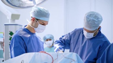 Klinikteki tıp uzmanlarının cerrahi prosedürü. Ameliyat sırasında bir grup profesyonel cerrah ve hemşire. Modern ameliyat salonu.