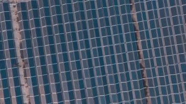 Büyük yenilikçi güneş çiftliği. Binanın düz çatısındaki fotovoltaik güneş panelleri. Alternatif enerji. Hareket eden kamera var. Hava görünümü.