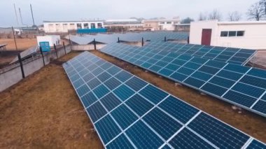 Güneş pilli bir alan. Modern güneş enerjisi santralinin mavi güneşli bataryalarının üzerinde uçuyor. Güneş enerjisi toplamak için güneş kremi çarşafları..