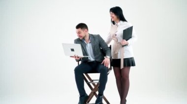 Stüdyonun arka planında mutlu genç bir çift. Yanında laptopuyla oturan yakışıklı iş adamı ve gülümseyen sekreter kız..