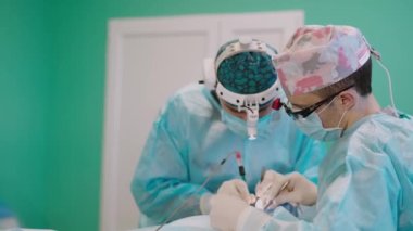 Otoplasti ameliyatı. Çıkıntılı kulakların düzeltilmesi. Ekip cerrahı ameliyathanede..
