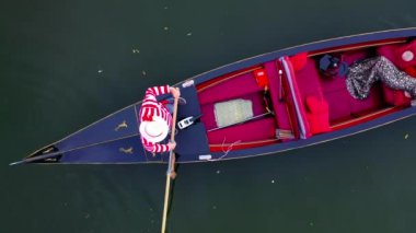 Gondolda yatan lüks kadın. Güzel kız Venedik 'te bir tekneyle seyahat ediyor. Gondolcu, suda bir gondol işletiyor. Kamera yükseliyor.