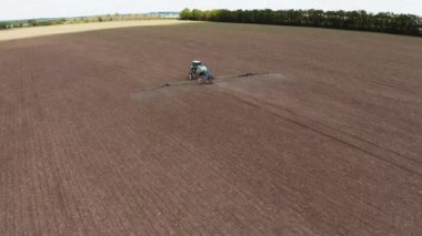 İlkbaharda tarım alanında. Özel ekipman püskürtme alanı olan bir traktör. Mevsimlik işler sırasında makinelerle sahada uçup kimyasallar saçıyorlar. Hava görünümü.