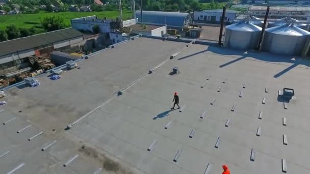 在屋顶上建造一个新的太阳能农场 工业大厦楼顶的全景全景 工人们正在为未来的太阳能电池板安装基础 空中景观 — 图库视频影像