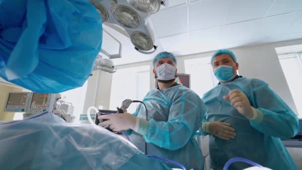 手术期间对病人进行专业的外科医生检查 在现代医院里 穿着医疗制服为病人做手术的医生 — 图库视频影像