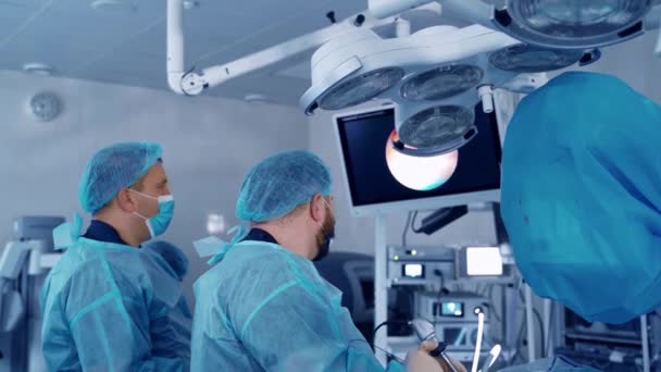 医師は手術中にモニターを見ている 病院の近代的な手術劇場での手術 医療コンセプト — ストック動画