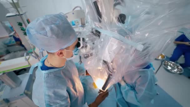 Neurokirurgi Operationsstuen Kirurg Blå Medicinsk Uniform Udfører Operation Gennem Mikroskopet – Stock-video