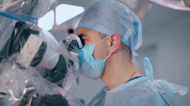 Процесс Нейрохирургии Хирург Медицинской Шляпе Маске Смотрит Современный Микроскоп Врач — стоковое видео