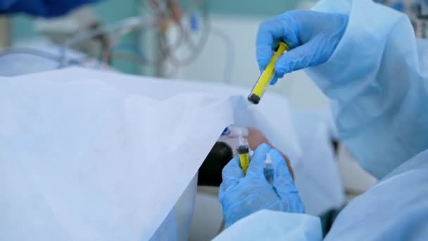 看護師の手は 患者の手の近くに無菌手袋に入れられています 医療従事者は クリニックで患者の命を救う間に注射する クローズアップ コロナウイルス 疫学コンセプト — ストック動画