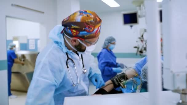 外科医による現代演劇 外科手術を終了する 外科医は現代の医療機器を切り替える 外科デスクに横たわる患者さん — ストック動画