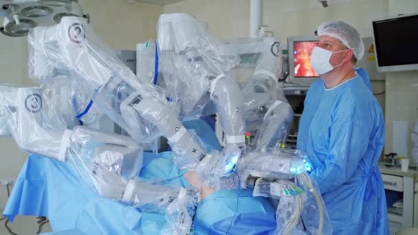 医療ロボットの近くの専門医 手術室でのロボット手術 ロボットを含む医療活動 革新的な医学 — ストック動画