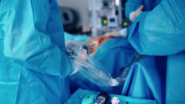 ロボットデバイスによる手術プロセス 保護制服の外科医チームが病院で手術を行っています 医師はハイテク機器を使用しています クローズアップ — ストック動画