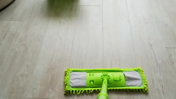 家里木地板上的绿色拖把和桶 家庭主妇用现代的微纤维刷子擦地板 日常活动 — 图库视频影像