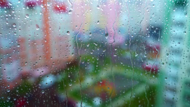 雨天的窗户在模糊的城市背景上 窗户玻璃上的雨滴湿透了 摘要雨滴景观背景 — 图库视频影像