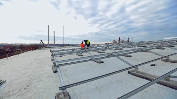 Künftiger Solarpark Auf Flachdach Zwei Arbeiter Schutzanzügen Installieren Metallbasis Für — Stockvideo