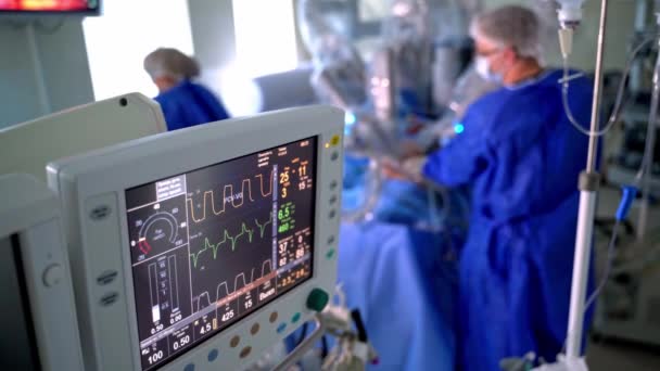 モニターは手術中に患者の状態を示しています クリニックのぼやけた操作プロセスに関する最新の医療機器 — ストック動画