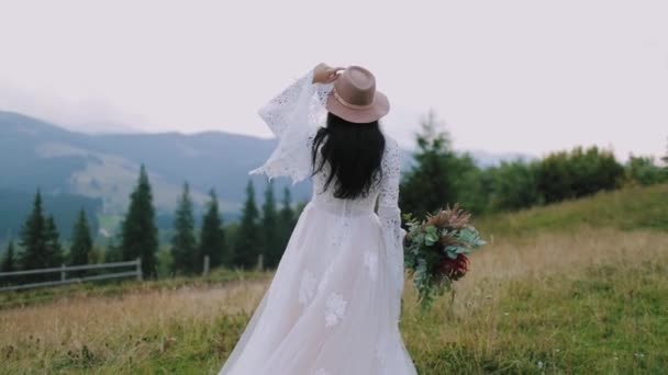 Rückansicht Einer Braut Den Bergen Mädchen Brautkleid Und Rosa Hut — Stockvideo
