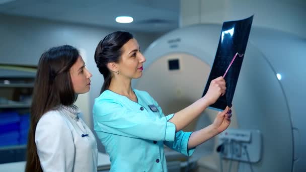 Női Specialisták Elemzik Röntgenképet Röntgenképet Vizsgáló Előrehaladott Klinikán Betegbetegségről Beszélő — Stock videók