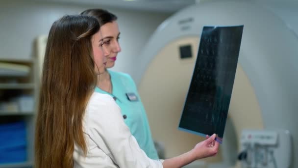 女医生在现代诊所检查X光检查 两名妇女专家研究放射学图像并进行诊断 — 图库视频影像