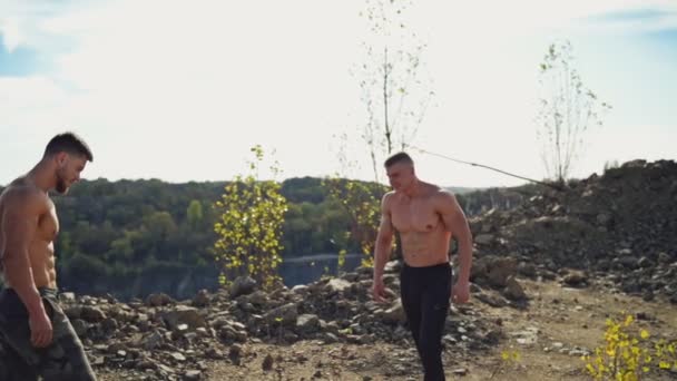赤身裸体的运动员在山上握手 两个肌肉发达的男人在大自然的背景下互相致意 慢动作 — 图库视频影像