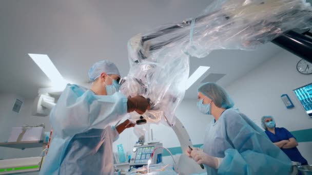 専門医と看護師が手術をする 外科医はオペレーティング シアターで最新の医療機器を使用しています クリニックにおける神経外科 — ストック動画